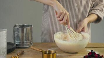 The chef vigorously whisks the flour and egg dough, creating a pie filled with fresh cranberries, blueberries, and other berries. video