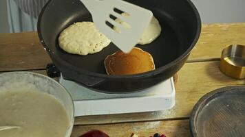 cook was not paying attention to pancakes as they were frying in pan. This caused them to burn on one side and become black. video