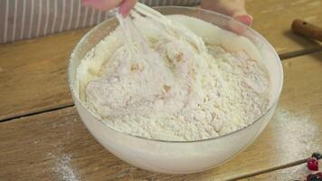 Pastry chef uses whisk to combine flour, egg, and baking powder to create base for baking various types of pastries, including pies, pancakes, and pizza. video