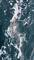 Top view from deck of ship to depths of undulating dark blue surface of cold Arctic Ocean stretching to horizon. Calm deep sea. In distance, huge grey rocks can be seen. video