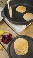 The chef expertly turns the pancakes, frying them in the hot pan, to guarantee they are cooked thoroughly. video
