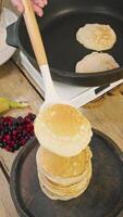 Chef completes preparation of the pancakes and puts them on a serving platter. The dish is then served in cafe with portion of fresh berries. video