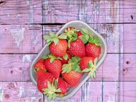 A bowl of strawberries on a wooden table video