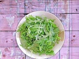 A plate of arugula on a pink wooden table video