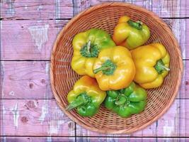 A basket full of yellow and green bell peppers on a wooden table video