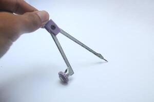 man's hand holding a compass to make a circle, office equipment, equipment for engineers photo