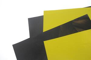 black and yellow origami paper stacked on white background photo