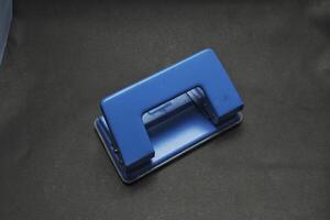blue paper punch with black background photo