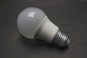 white light bulb isolated on black background photo