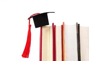 A Graduation cap placed on a stack of books. It is the concept of education, knowledge, learning and successful. photo