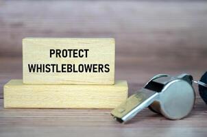 Protect Whistleblowers text on wooden blocks with whistle background photo