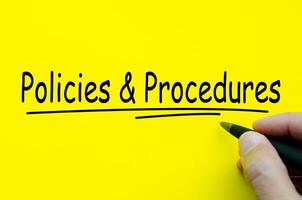 Policies and Procedures hand written text on yellow notepad photo