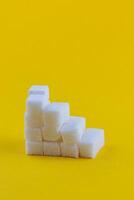Stack of sugar cubes arranged in an abstract pattern on a bright background photo