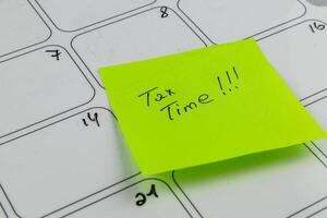 Reminder about tax deadlines on a calendar with a sticky note photo
