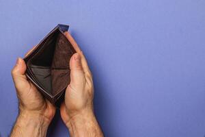 Struggling businessman examines empty wallet during financial crisis photo