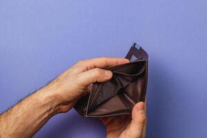 Businessman faces financial uncertainty while checking empty wallet photo