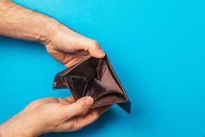 Struggling businessman examines empty wallet in financial crisis scene photo