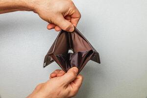 Struggling, businessman examines empty wallet amidst financial crisis photo