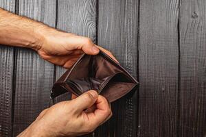 Struggling businessman examines empty wallet in time of financial crisis photo