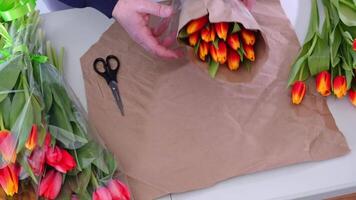 Wrapping vibrant tulips by hand with careful precision in floral arrangement video
