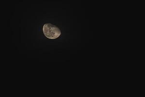 A luminous crescent moon illuminating a tranquil night sky above photo