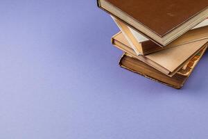 Stacked vintage books resting on a lavender background in a cozy setting photo