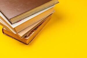 Stacked books on a bright yellow background for an engaging study session photo