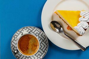 Enjoying a delightful lemon tart with a rich espresso on a bright blue table photo