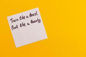 Motivational phrase written on a sticky note against a bright background photo