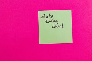 Motivational note on bright pink background encourages action today photo