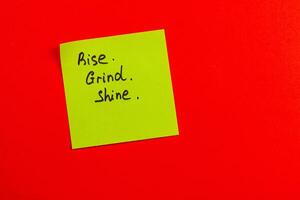 Motivational sticky note on bright red background encouraging daily effort photo