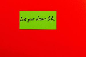 Inspiring note on colorful background encouraging you to live your dream life photo