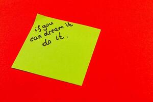 Inspirational note on bright colored background encourages action and dreams photo