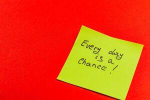 Motivational sticky note on vibrant red background for daily inspiration photo