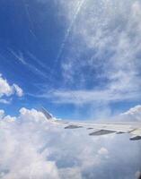 Airplane Wing Above Fluffy Clouds Serene Blue Sky View photo