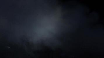 Silhouette of a keyboard player between smoke and lights in a concert video