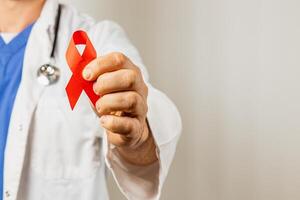 Physician holds red ribbon symbolizing support for HIV awareness campaign photo