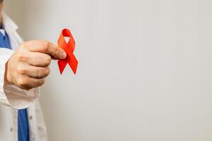 Healthcare professional holds red ribbon symbolizing awareness and support photo