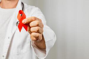 Healthcare professional raises awareness with red ribbon symbolizing support photo