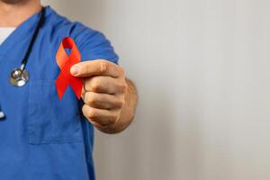 Health professional holds red ribbon for awareness on HIV and AIDS photo