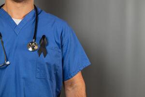 Healthcare worker wearing blue scrubs with black ribbon for mourning photo
