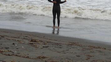 Triathlete in the beach with rough waves before start a triathlon video