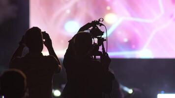 amera operator working in a concert with big psychedelic screen video