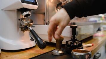 Barista tamps coffee in a portafilter with an old manual tamper inserts it into the espresso machine and prepares a drink precise process professional technique espresso brewing artistry video