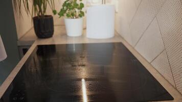 Woman uses a scraper to clean a glass cooktop, removing stains and ensuring a spotless surface video