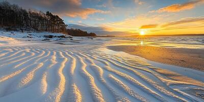 Stunning Winter Sunset on Snow Covered Beach with Rippled Sand Patterns photo