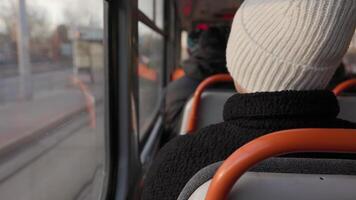 View from Behind of a Woman in a White Hat Looking Out a Tram Window video