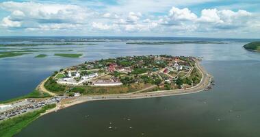 A scenic aerial view of Sviyazhsk, a historic island town in Tatarstan, surrounded by the Volga River. The island features colorful houses, ancient churches, and a road connecting it to the mainland video