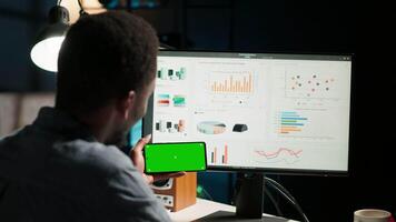 Young person does remote work using data finances with a green screen, examining statistics at his workstation. Investment advisor planning new strategy to obtain funds for development. Camera B. video