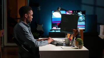 Young programmer engineer writing binary code data on terminal window, doing freelance work at home setup. Software developer working on troubleshooting with programming language. Camera B. video